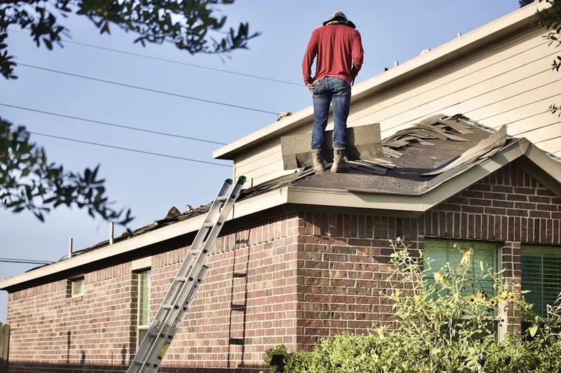 Professional roofer working on a residential roof in River Road